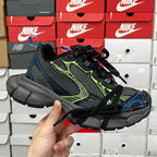 Unisex running shoe in black and gray with neon green and blue accents, lace-up.
