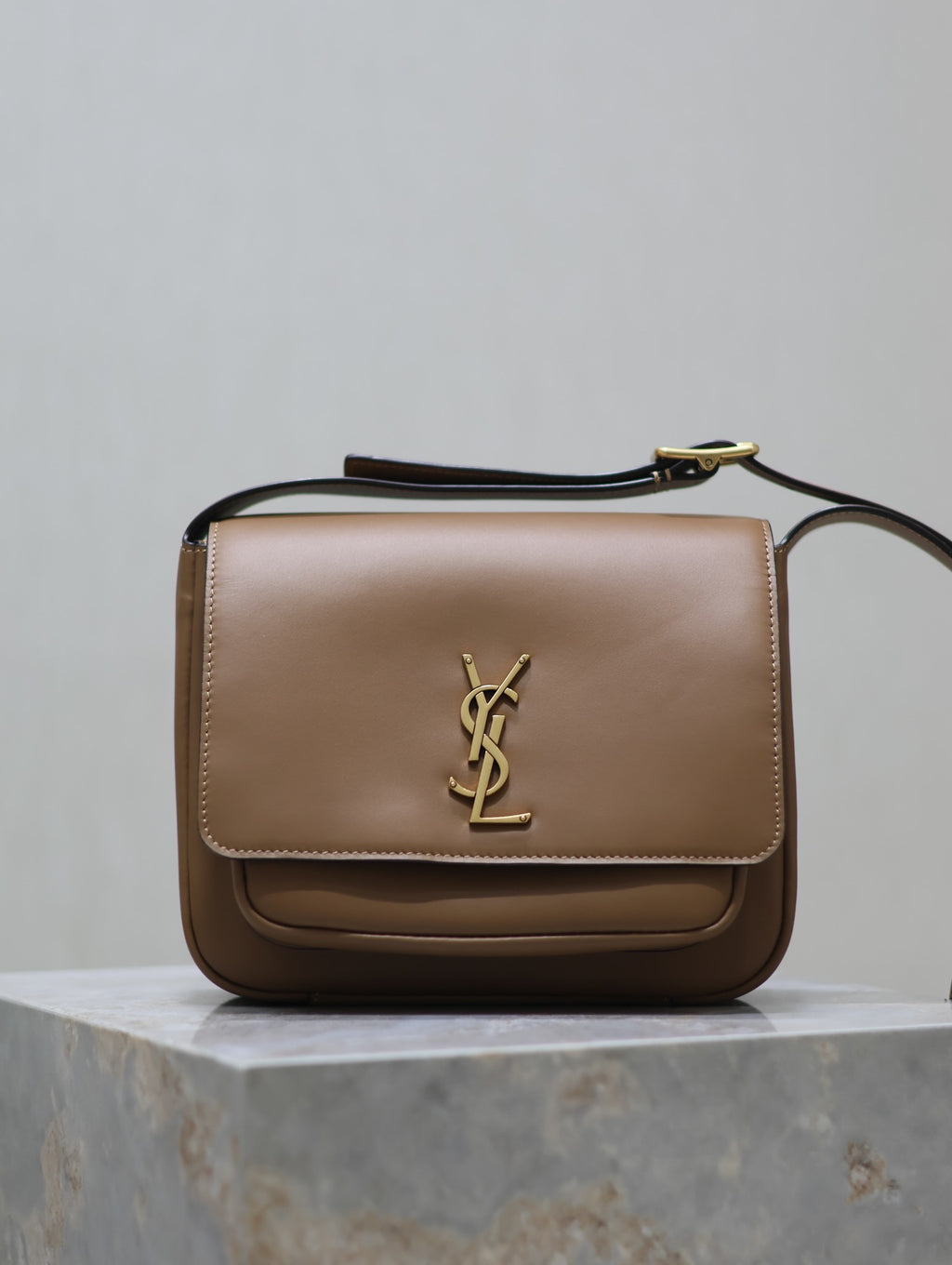 Tan leather crossbody bag with gold YSL logo on front flap