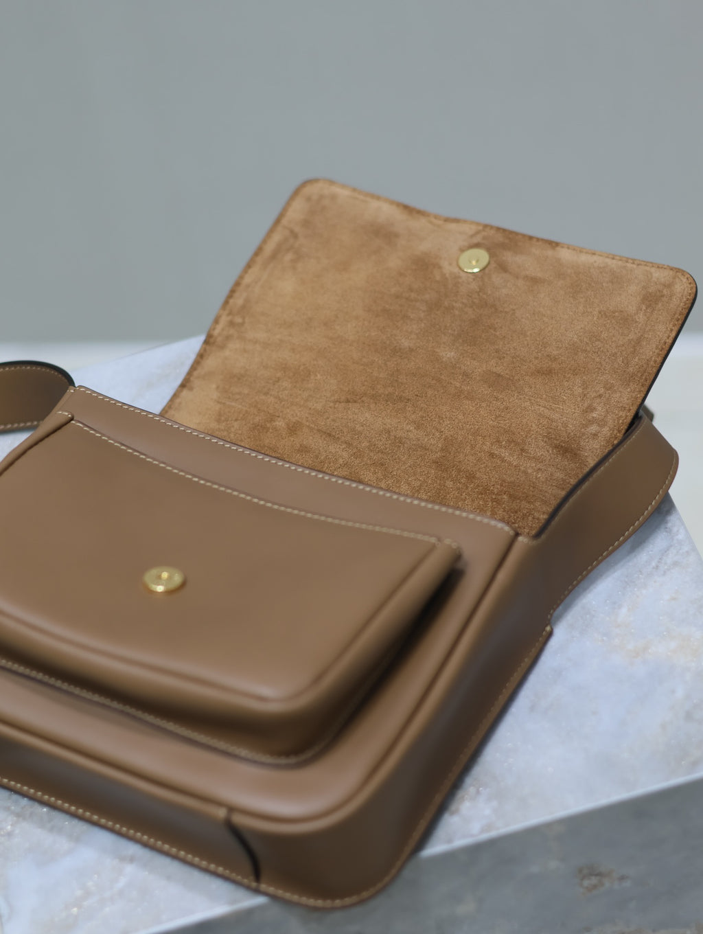 Tan leather flap bag with gold snaps and suede-like interior panel