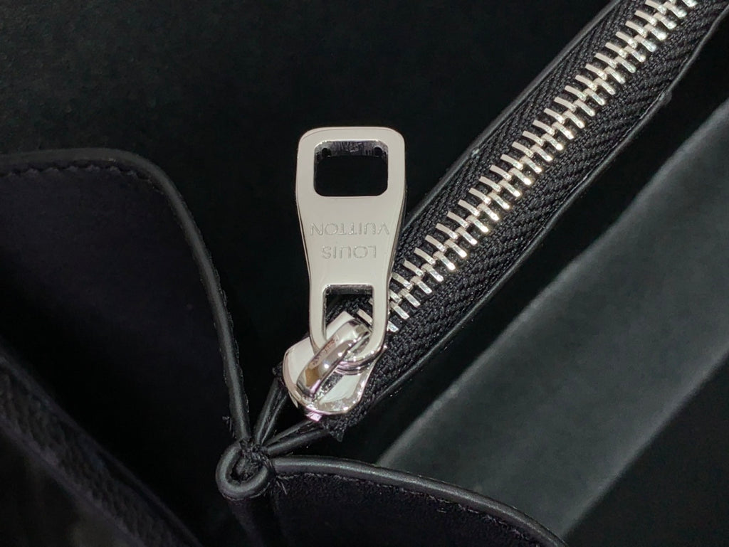Men's Louis Vuitton bag close-up of zipper pull with metal hardware
