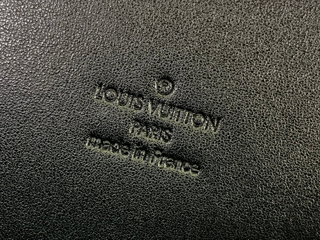 Louis Vuitton Paris embossed logo on dark leather texture