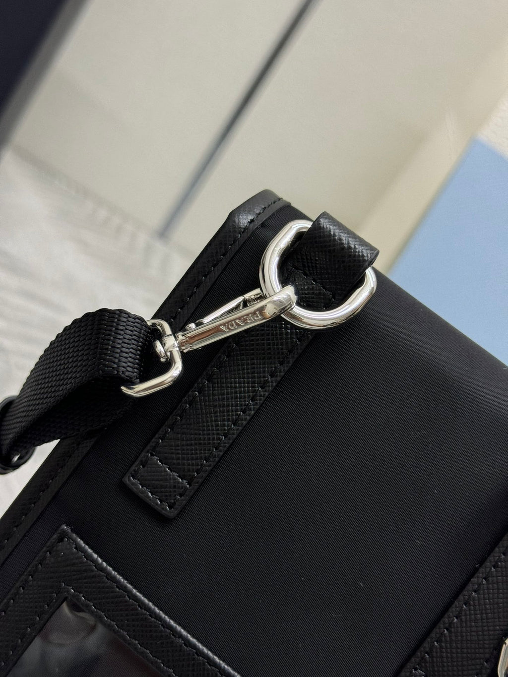 Prada black bag with metal D-ring strap attachment and front stitch detail