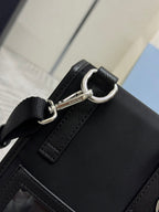 Prada black bag with metal D-ring strap attachment and front stitch detail