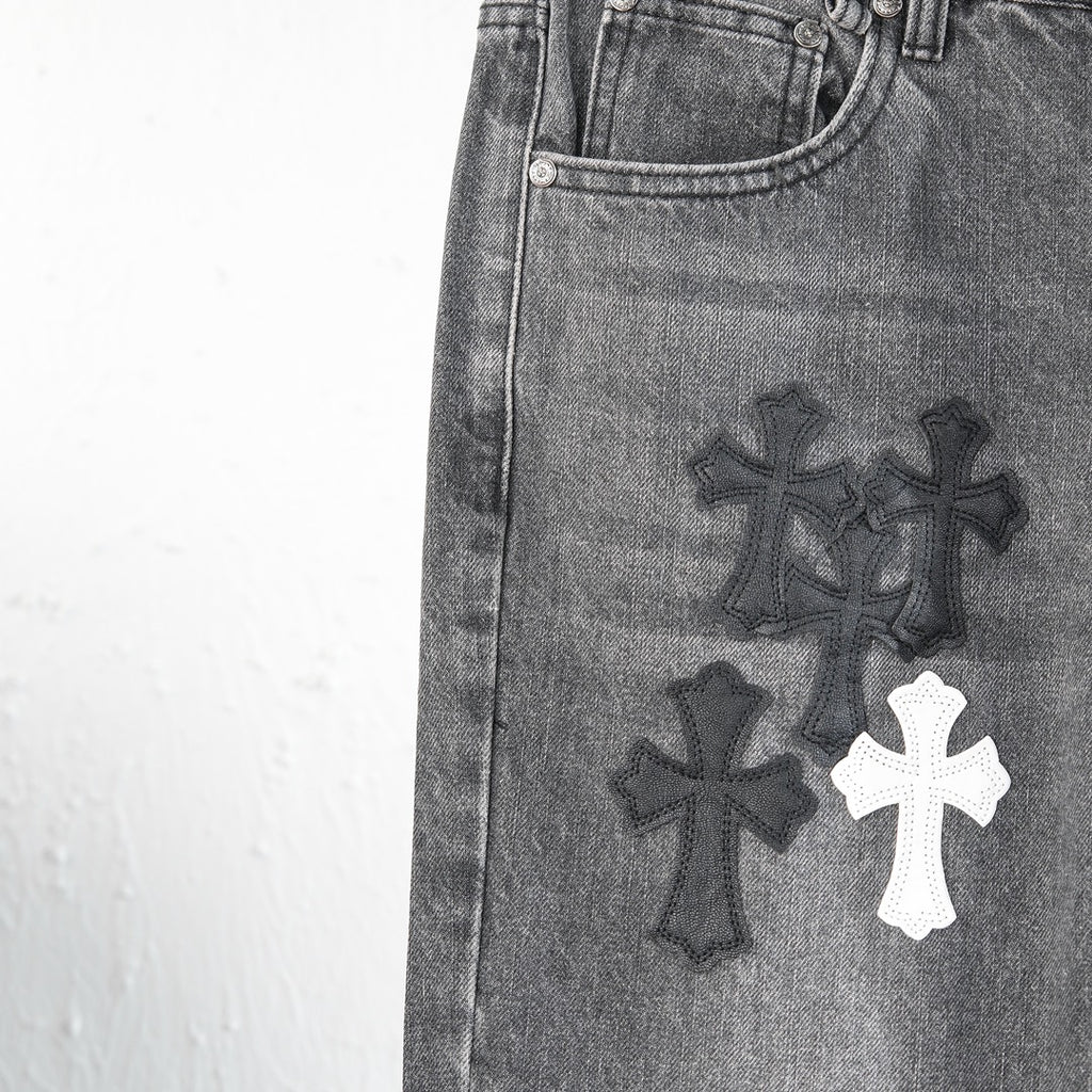 Chrome pants leg close-up with embroidered cross designs and white cross patch