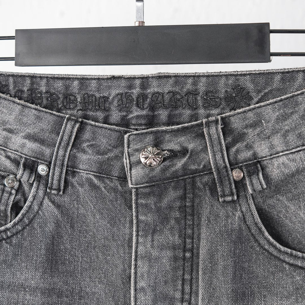 Chrome pants waist close-up with buttoned closure and metal flower belt detail