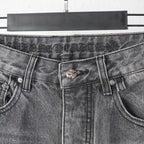 Chrome pants waist close-up with buttoned closure and metal flower belt detail