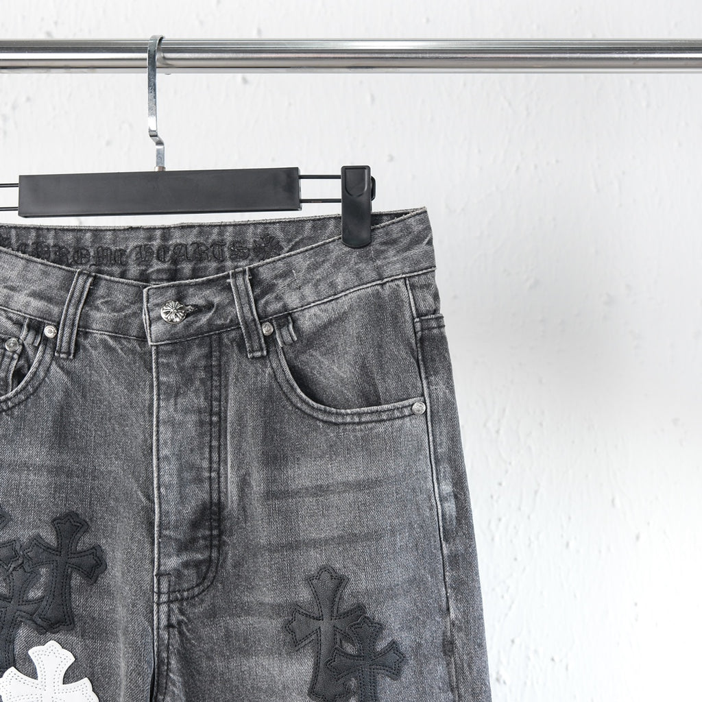 Chrome pants leg close-up with side pocket and cross patch graphic in dark denim
