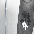 Chrome pants leg detail with dark and white cross appliques near the knee