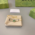 Gold charm bracelet with green enamel medallion and interlocking link