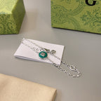 Gucci silver chain bracelet with green enamel center charm on card