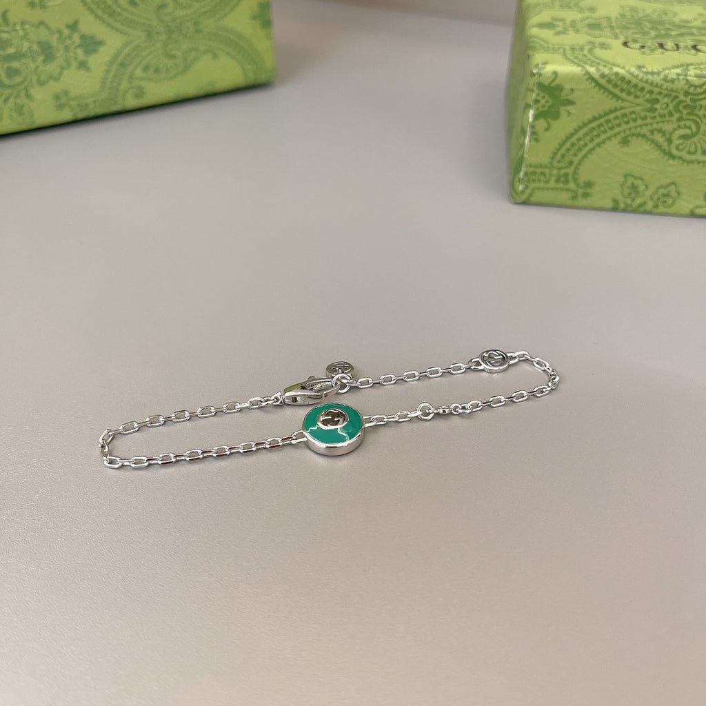 Gucci silver chain bracelet with green enamel charm, no packaging visible