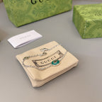 Gucci silver bracelet with green enamel charm on beige fabric pouch