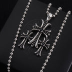Pendant necklace with large chrome cross charm, dark enamel and small stones