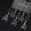 Chrome-toned pendant necklaces with cross motifs, red and blue enamel accents