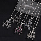 Chrome-toned pendant necklaces with cross motifs, red and blue enamel accents