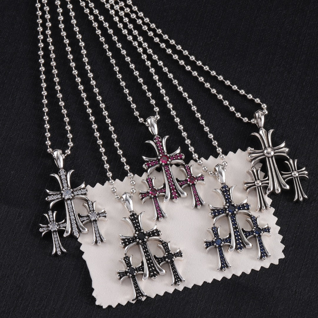 Pendant necklaces set with chrome cross charms and red/blue enamel, on display card