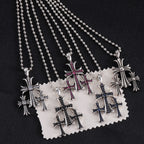 Pendant necklaces set with chrome cross charms and red/blue enamel, on display card