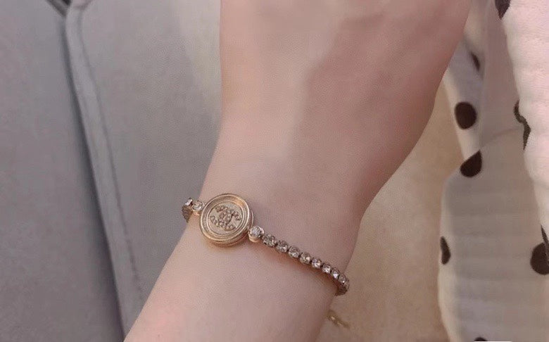 Chanel round logo bracelet on wrist with pearl-bead chain detail