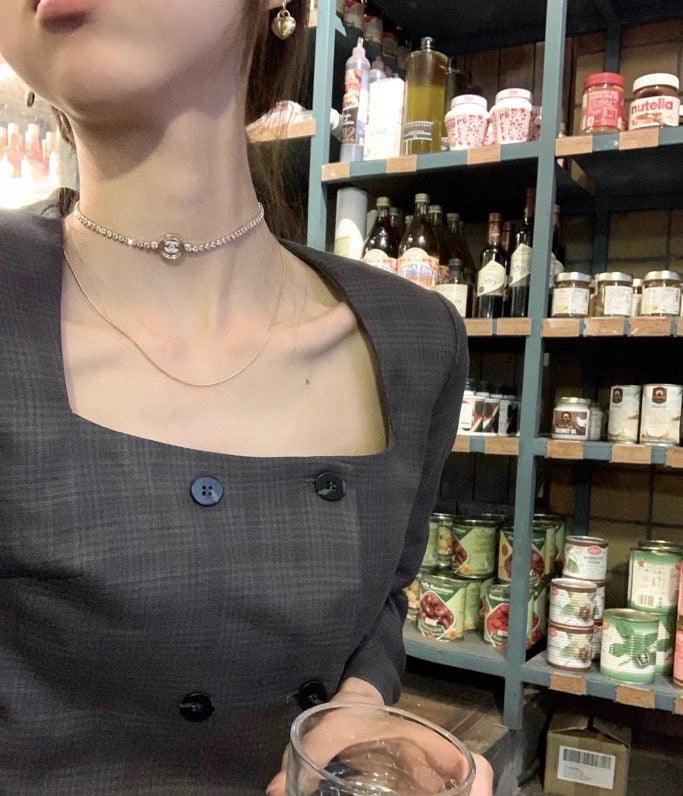 Chanel pearl-bead choker necklace with round logo pendant on dark dress