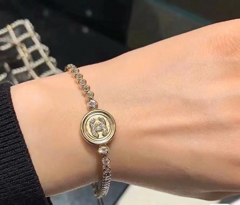 Chanel bracelet close-up with round logo charm and silver-toned beaded chain