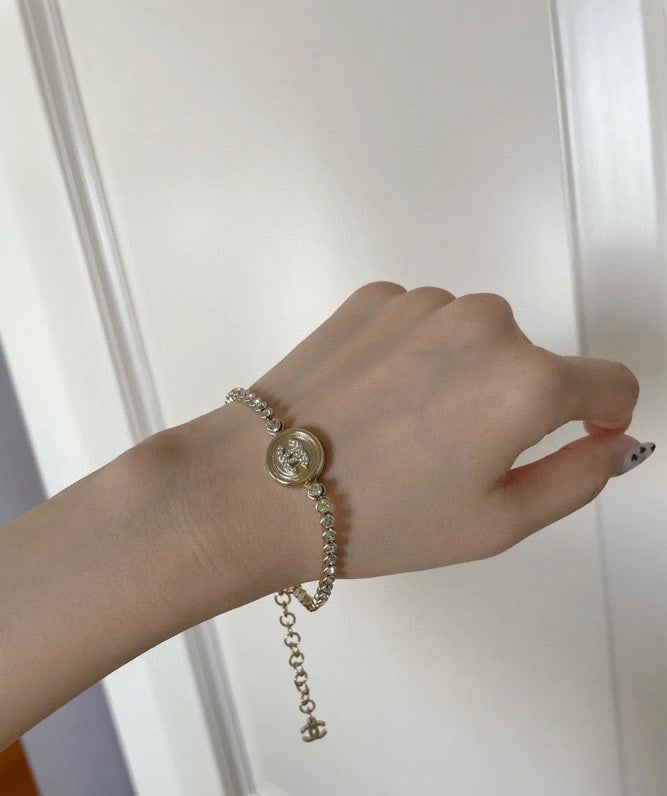 Chanel pearl-bead bracelet with round logo medallion and dangling chain charm