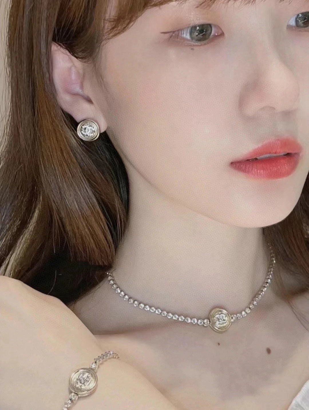 Chanel pearl choker necklace, round logo earrings, and matching bracelet on model