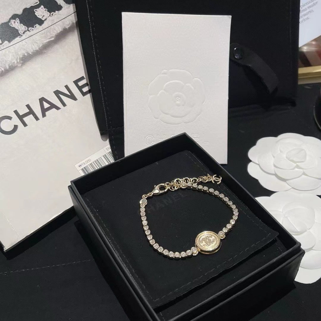 Chanel bracelet with pearl beads and round logo charm on black gift box