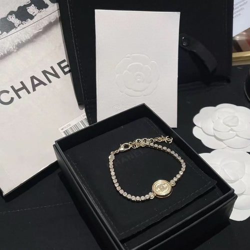 Chanel bracelet with pearl beads and round logo charm on black gift box