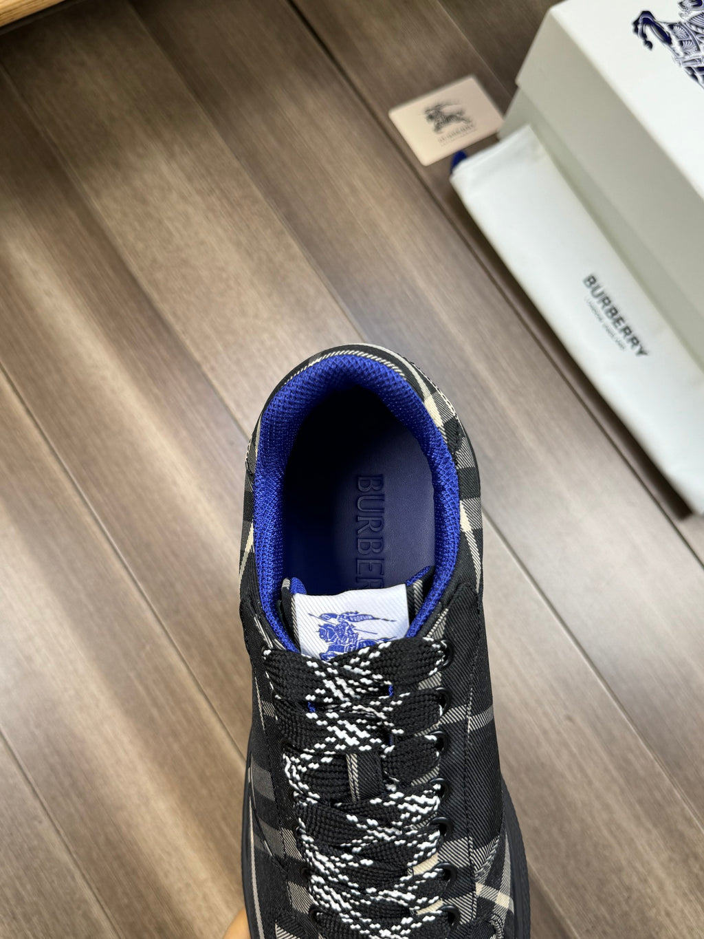 Burberry lace-up sneakers, front view with blue collar and black plaid upper