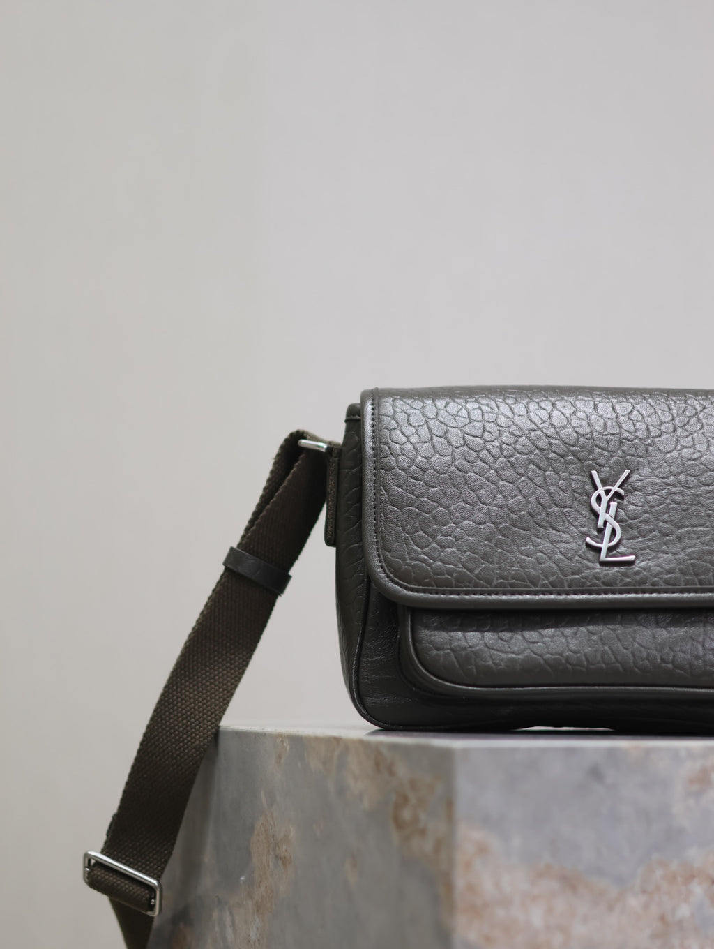 YSL flap crossbody bag side view with adjustable strap and textured leather finish