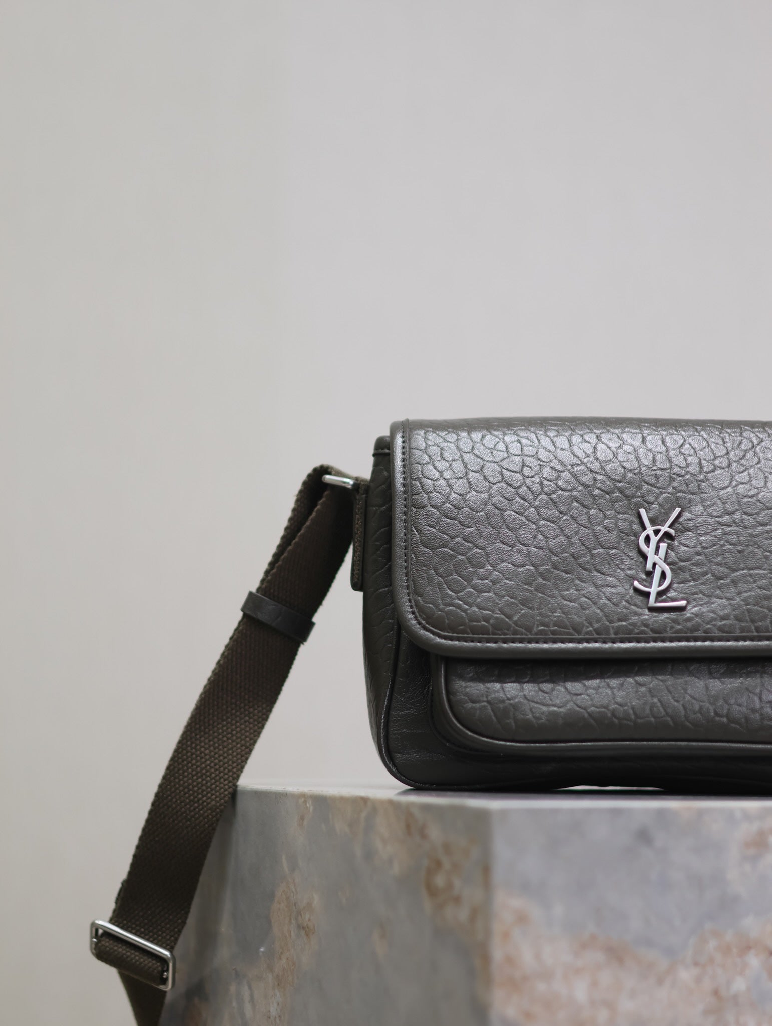 YSL flap crossbody bag side view with adjustable strap and textured leather finish