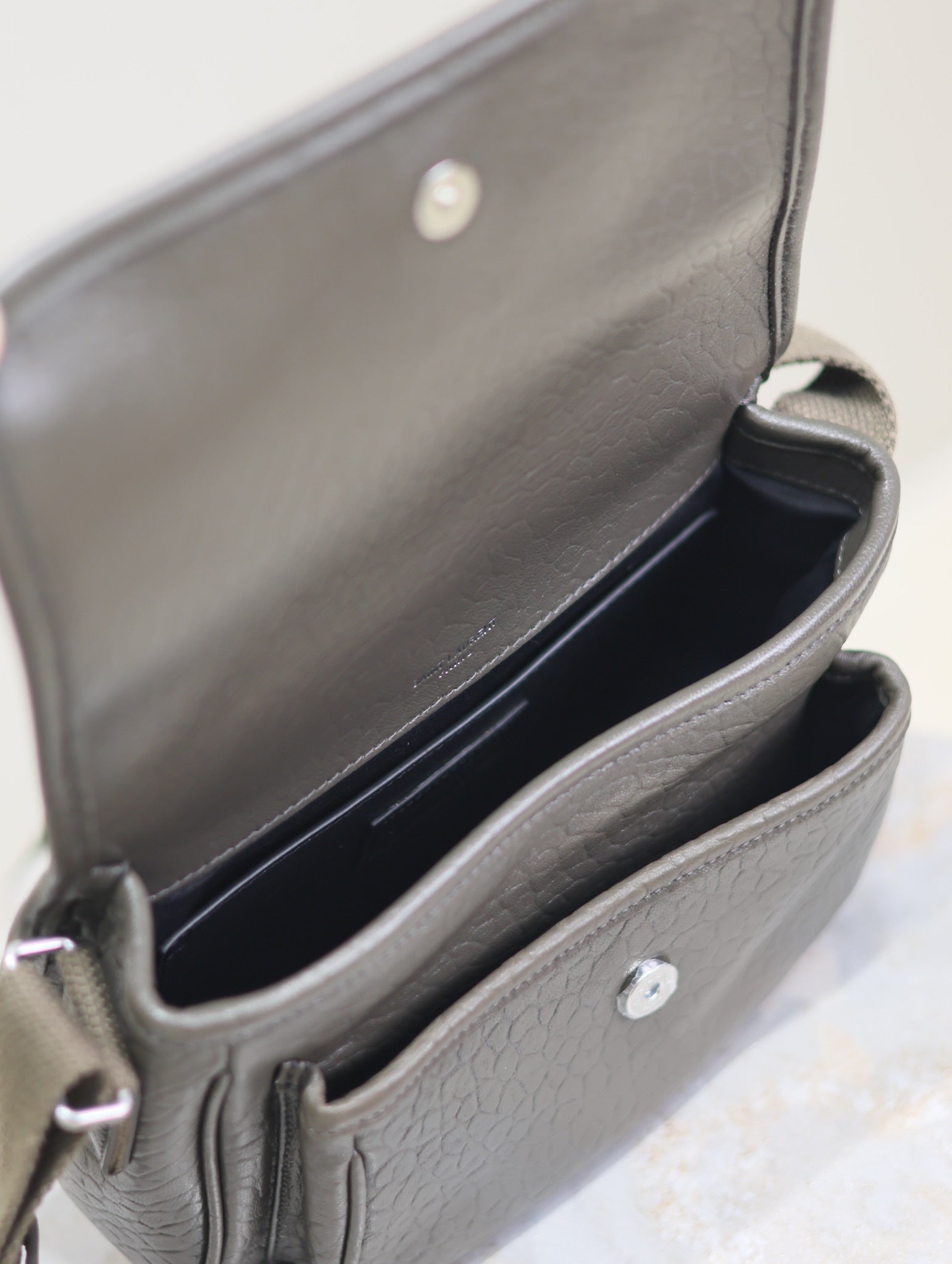 YSL crossbody bag open interior view with dark lining and front slip pocket