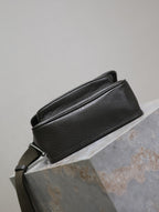 YSL crossbody bag rear view in black textured leather, strap across the back
