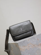 YSL flap crossbody bag angled front view in dark textured leather, silver logo
