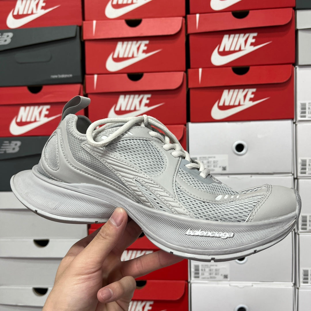 Light gray lace-up running shoes with textured knit upper and cushioned sole