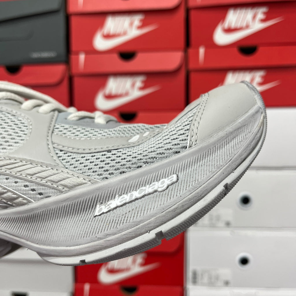 Light gray running shoe side view with sculpted midsole and brand logo