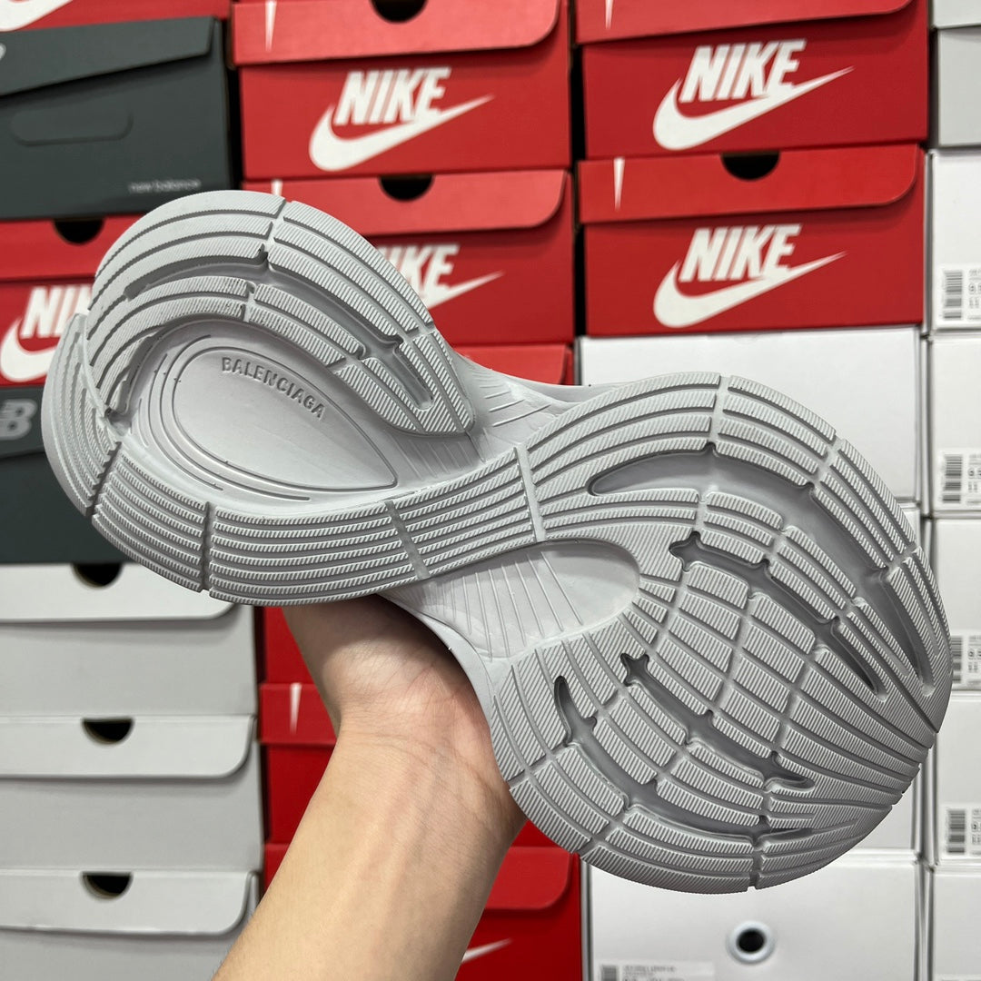 Light gray shoe outsole view with patterned traction tread