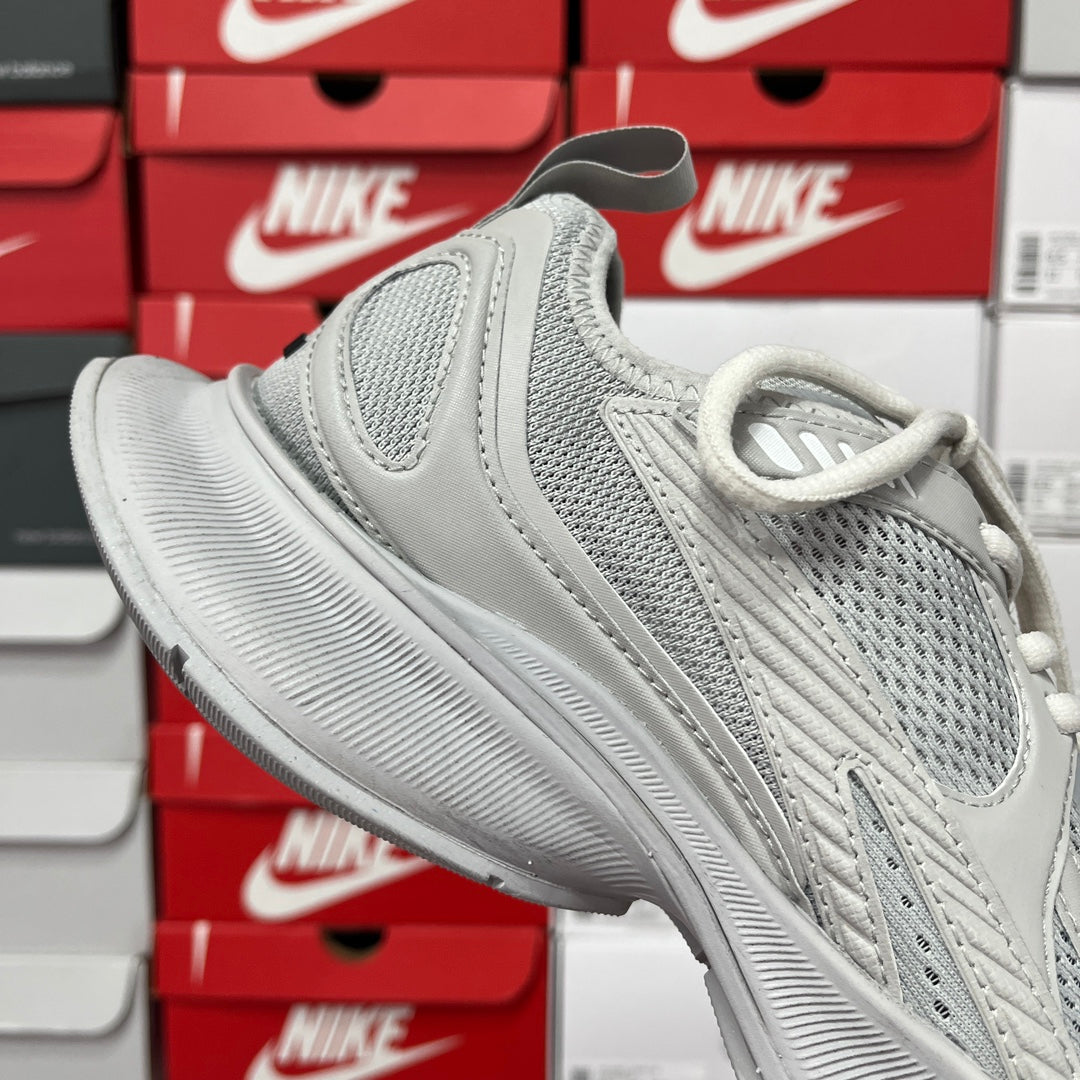 Light gray lace-up running shoes with layered strap details and cushioned sole