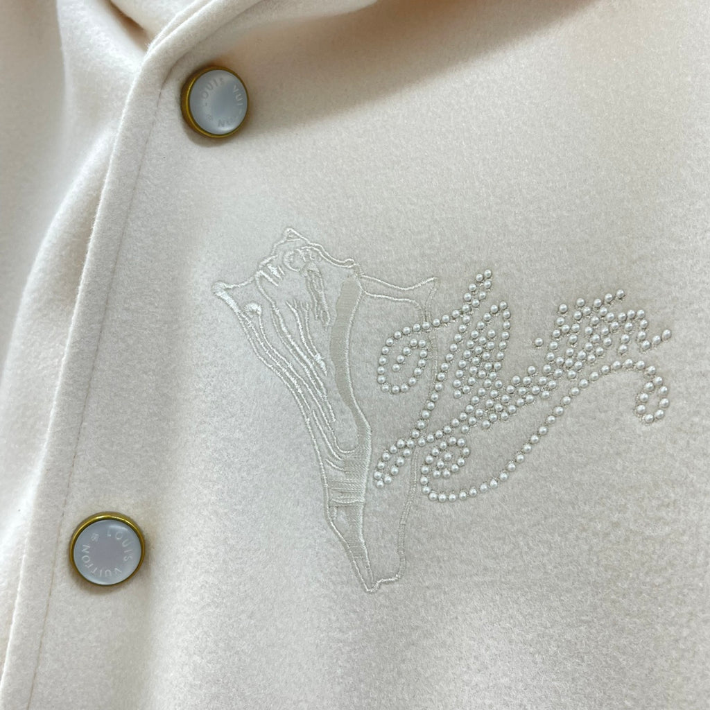 Cream jacket chest detail with rhinestone Louis Vuitton logo and gold-tone button