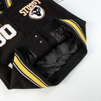 Black varsity jacket with ribbed yellow-and-white striped trim and snap pocket lining