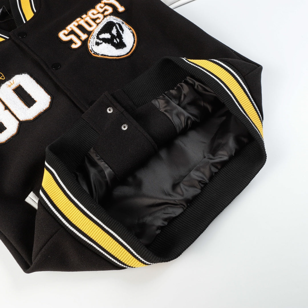 Black varsity jacket with ribbed yellow-and-white striped trim and snap pocket lining