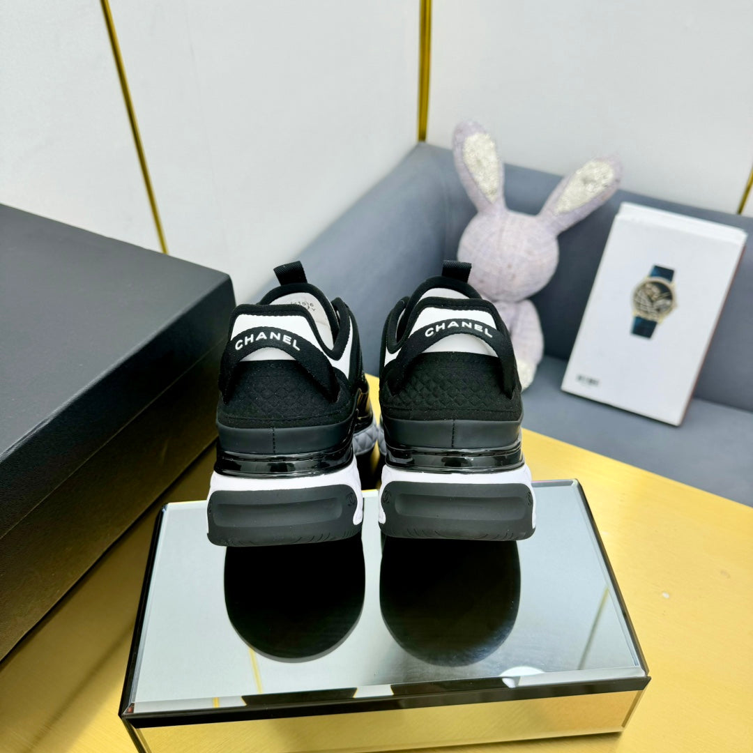 Back view of black lace-up sneakers with patterned uppers and cushioned heel