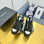 Two black lace-up sneakers with geometric patterned uppers and white side panels