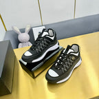 Pair of black lace-up sneakers with geometric patterned uppers and chunky white soles