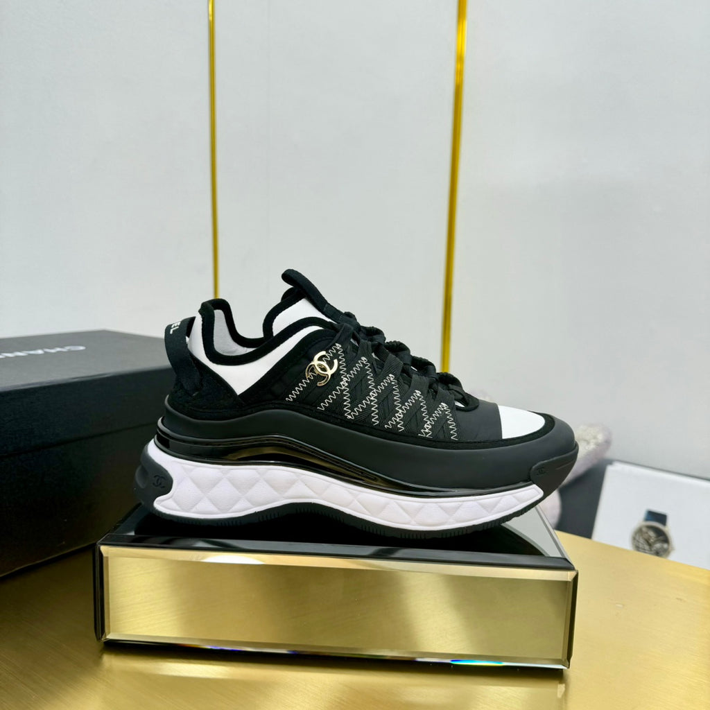 Black-and-white lace-up sneakers with patterned upper and white rubber sole
