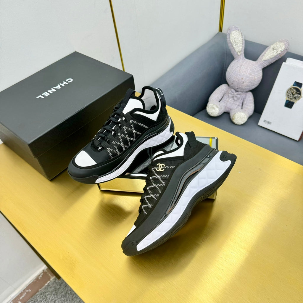 Lace-up sneakers with black patterned upper and white midsole, shown from side angle
