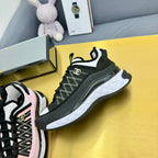 Close side view of black lace-up sneaker with white sole trim and patterned upper