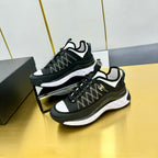 Black lace-up sneakers with patterned textile upper, white side stripe, and thick sole