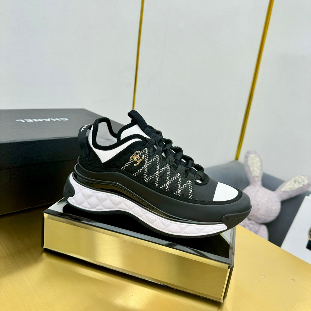 Lace-up sneakers in dark tones with patterned panels, white midsole, and low heel