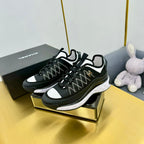 Black lace-up sneakers on display with patterned upper, white accents, and chunky sole